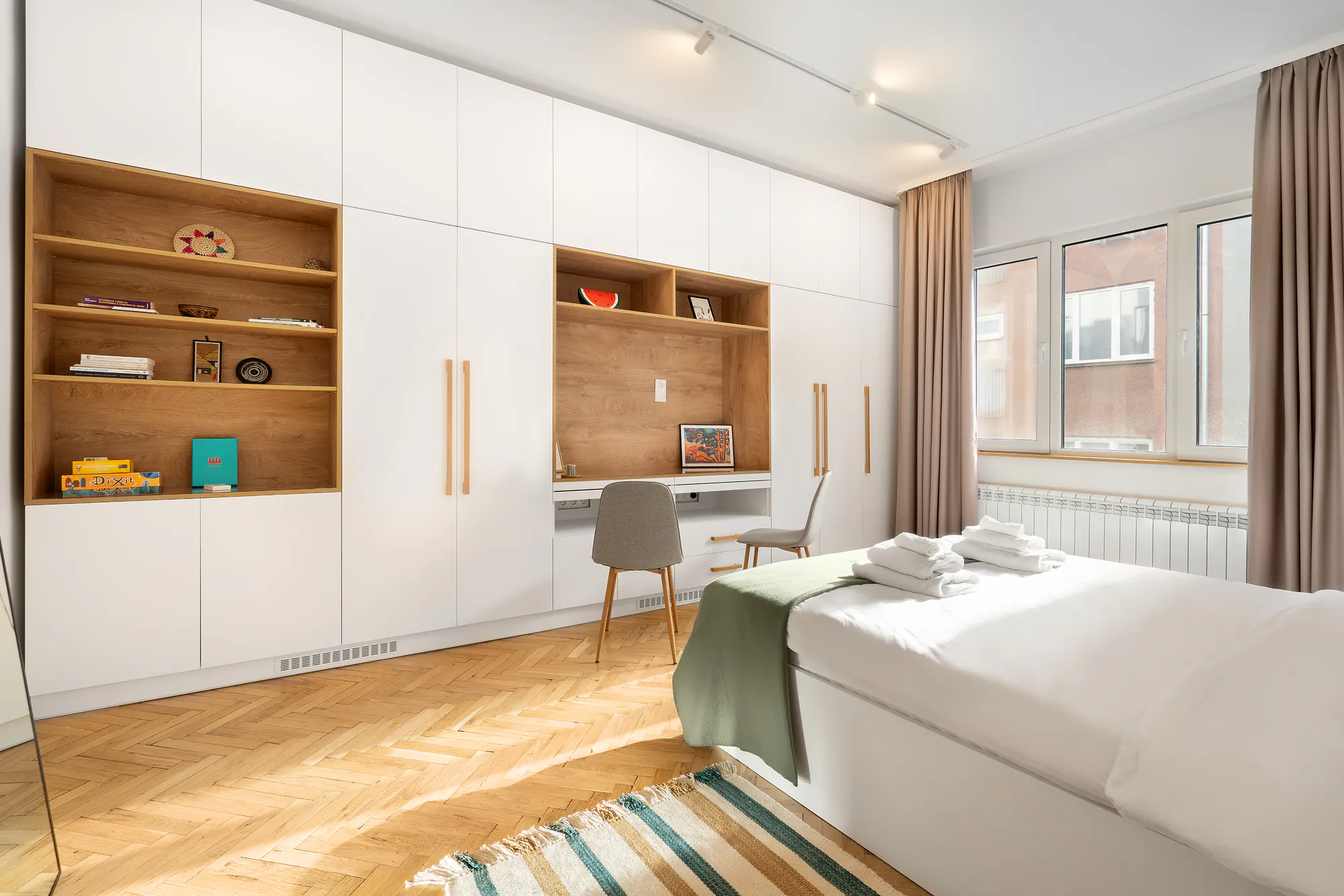Second bedroom with a wall-to-wall built-in wardrobe and a desk in a wooden niche