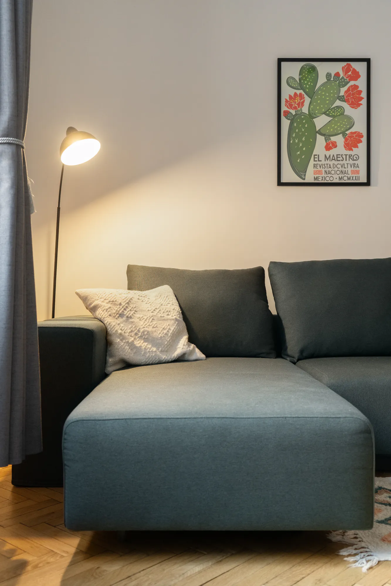 Living room detail: grey sofa, black floor lamp and a graphic poster