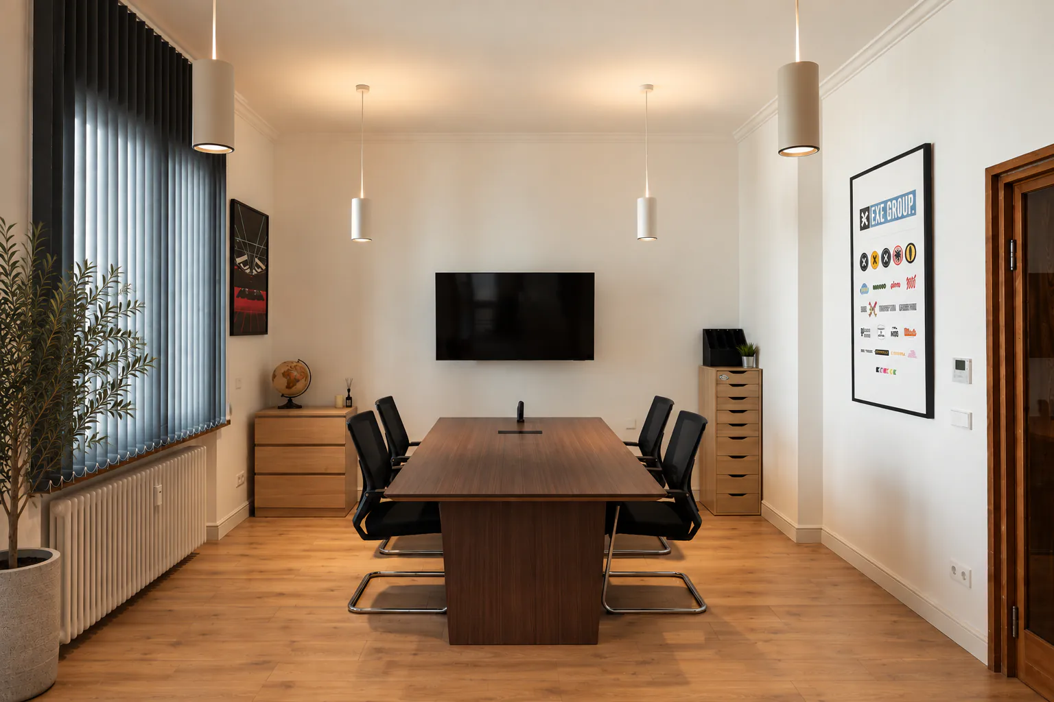 Meeting room with a walnut table, black chairs, blue blinds and an olive tree