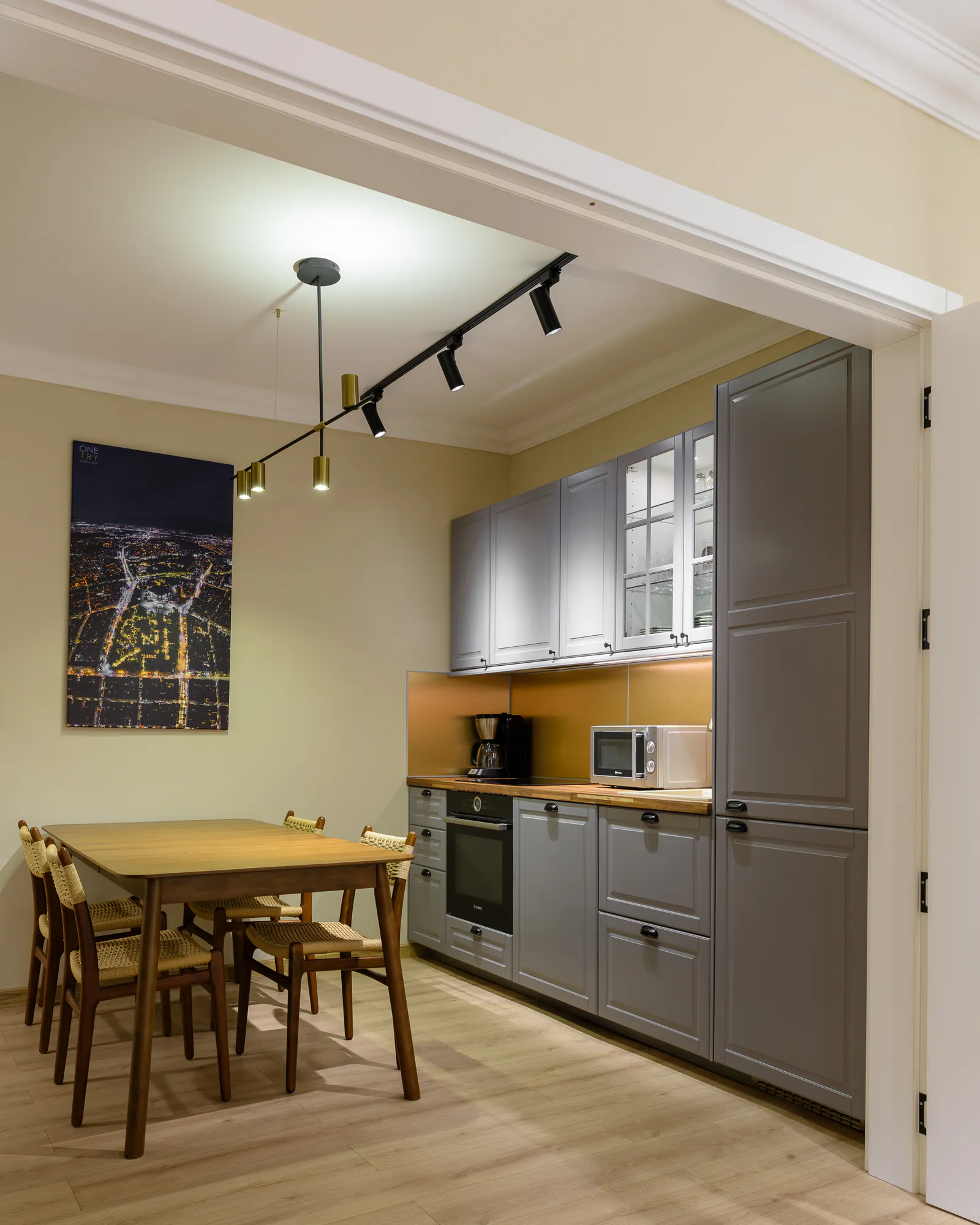 Kitchen with grey classic cabinets, a wooden worktop and a compact dining table