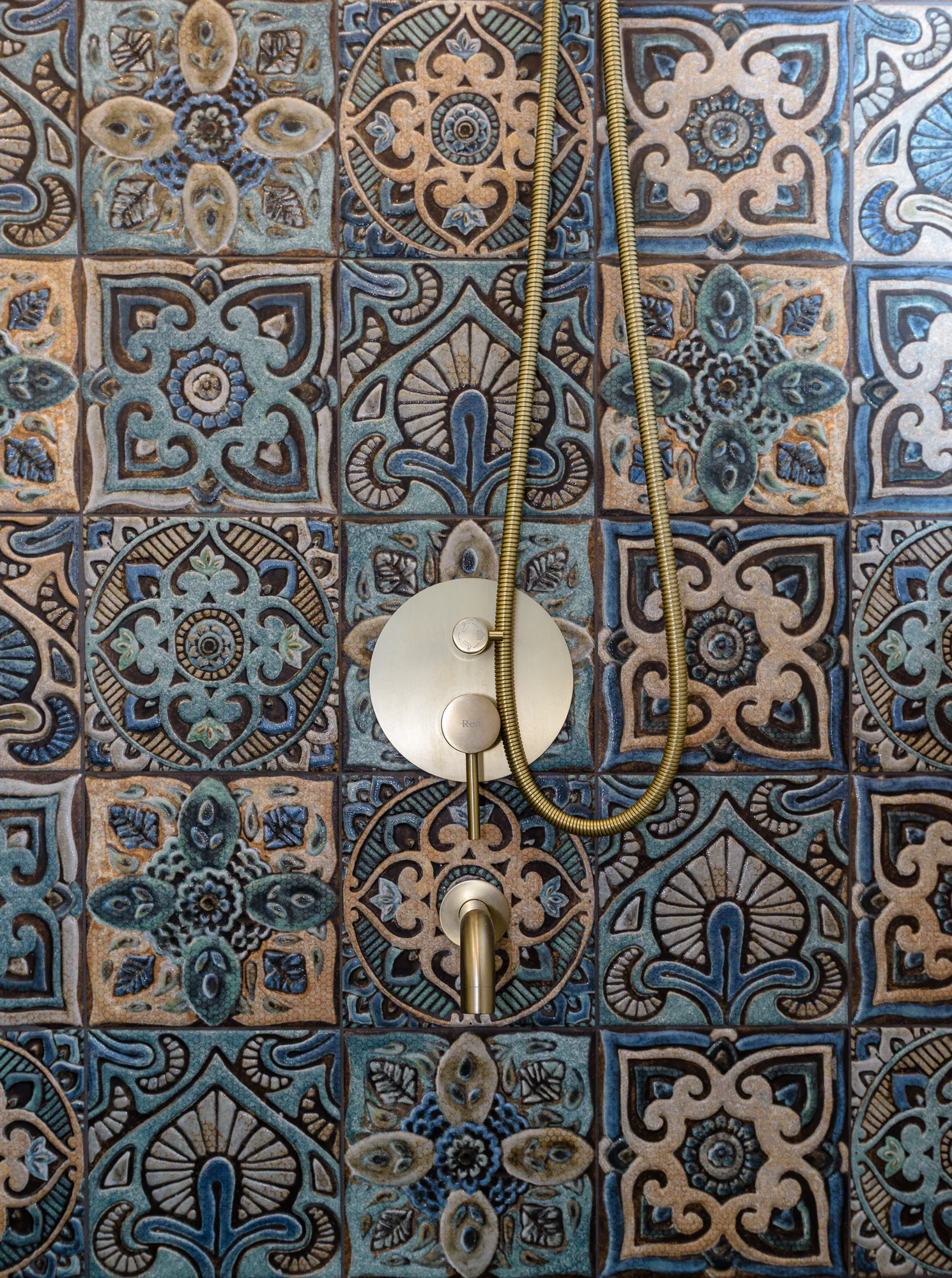 Ornamental tiles with a brass shower mixer