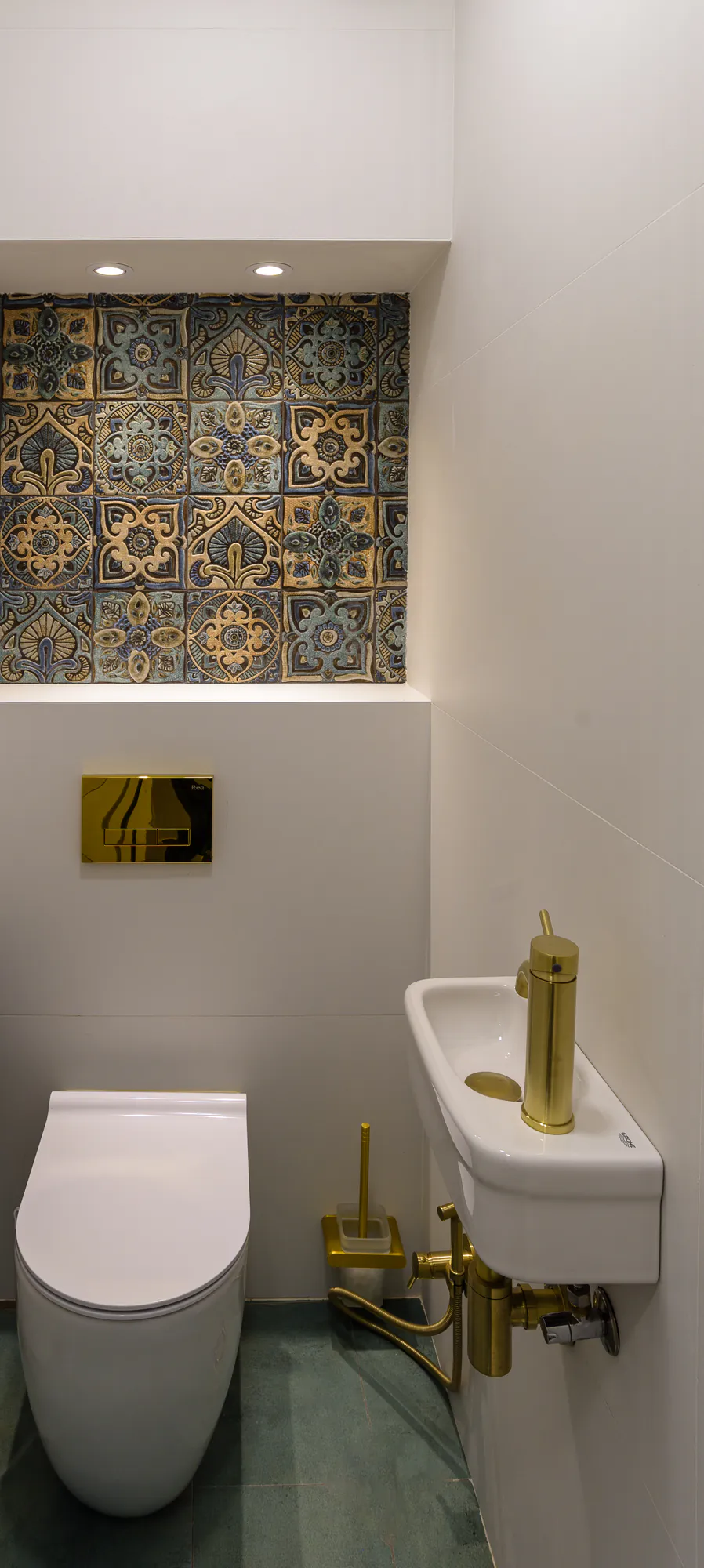 WC with a niche of decorative tiles and brass details