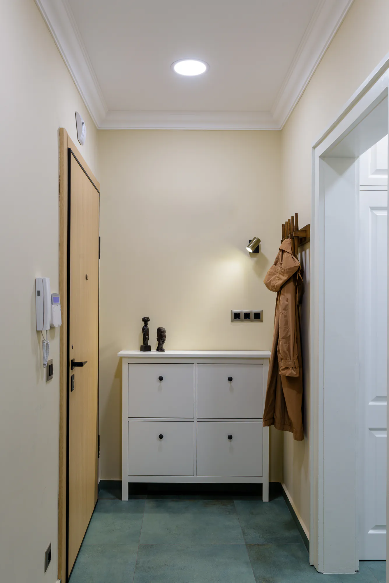 Entrance with a shoe cabinet, coat hooks and a wall light