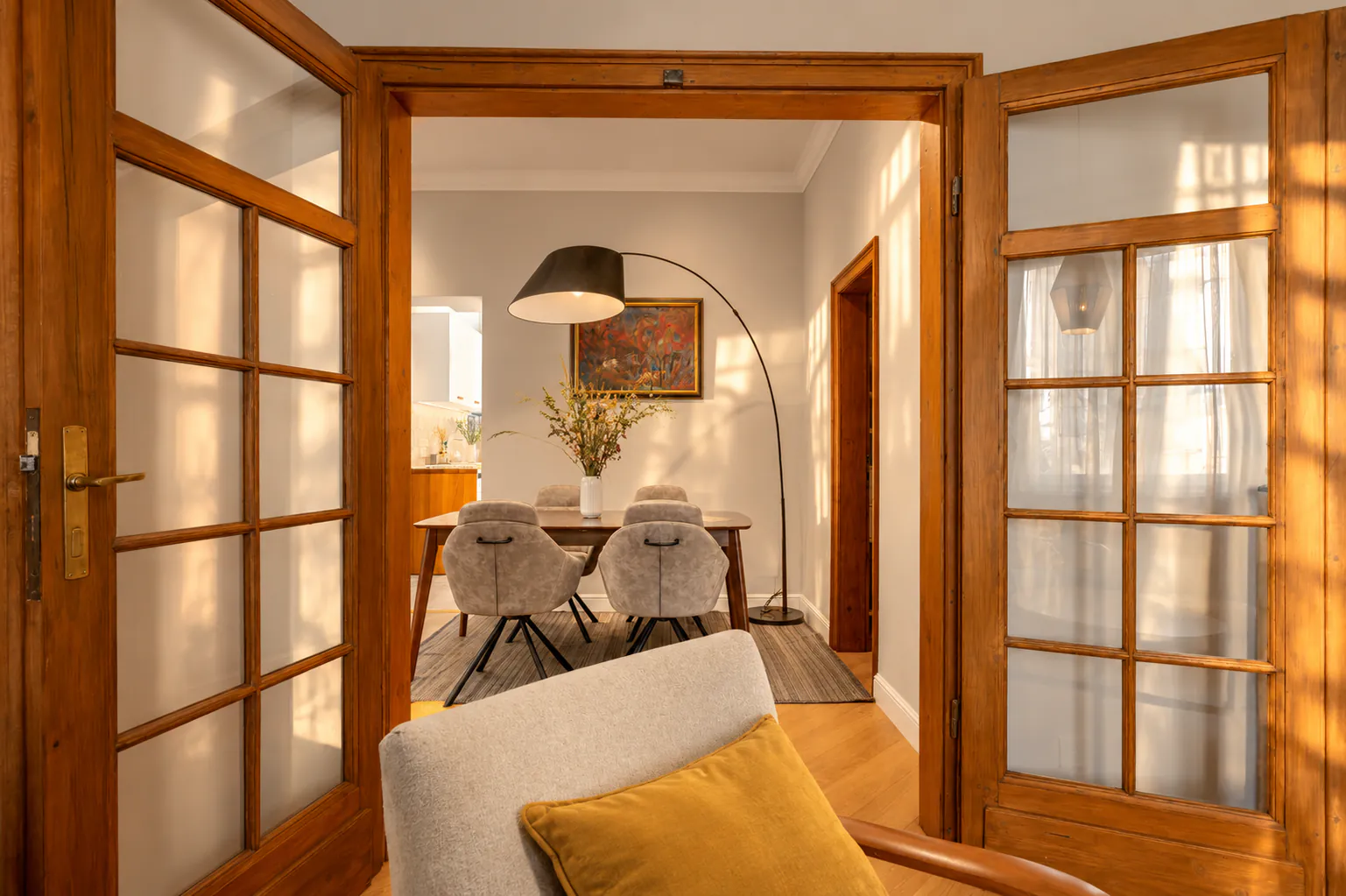 Living room with original double glazed doors to the dining room, blue armchairs and a rattan pendant