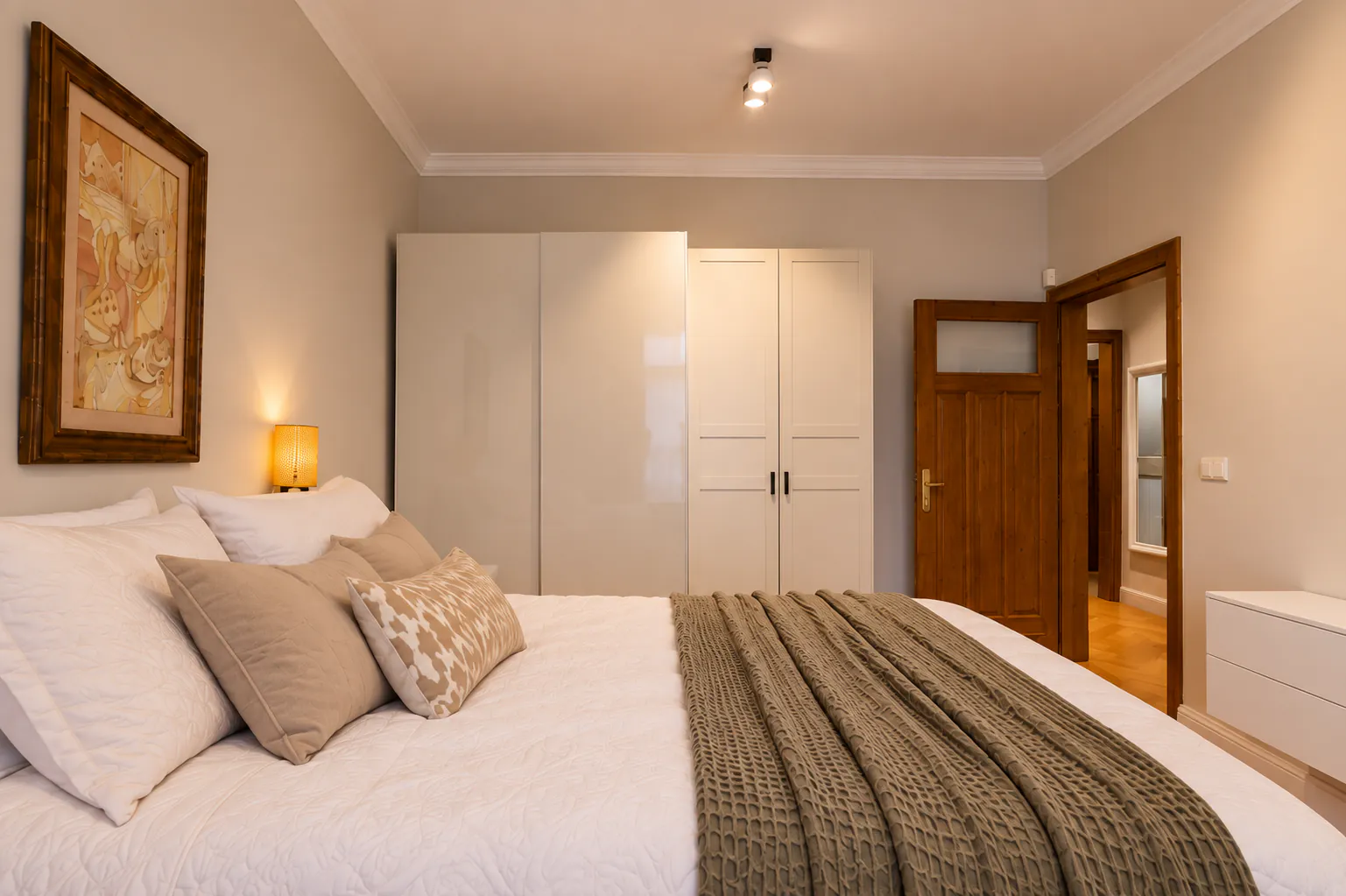 Bedroom with a white wardrobe and a preserved original wooden door